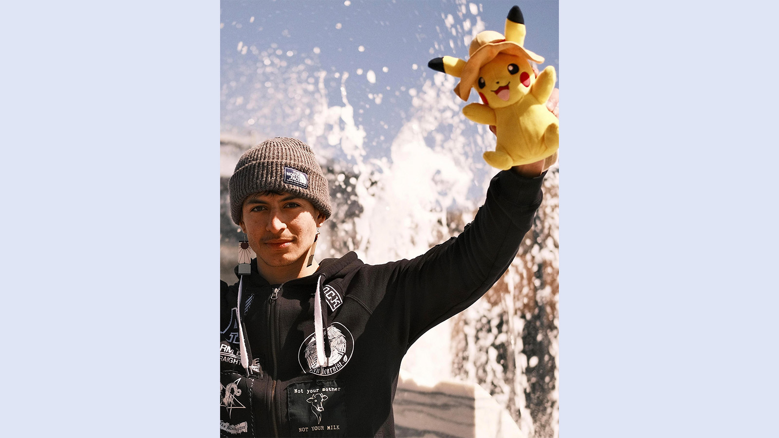 Photo of Ariel Parada in front of water fountain holding Pikachu plushie
