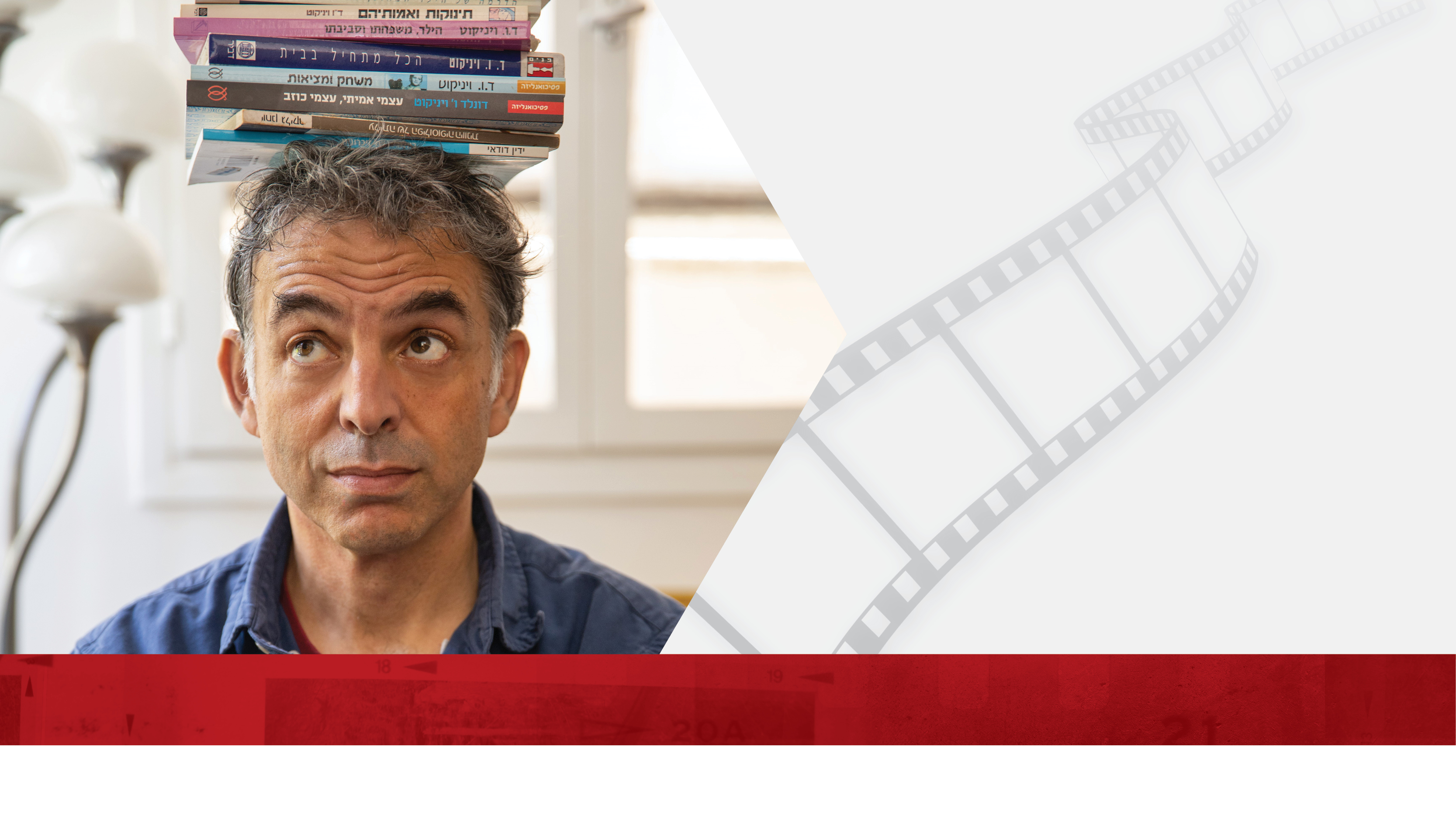  Headshot of writer Etgar Keret balancing books on his head.