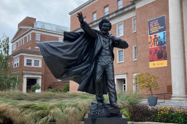 UMD statue of Frederick Douglass, orator, arm raised and cloak in motion