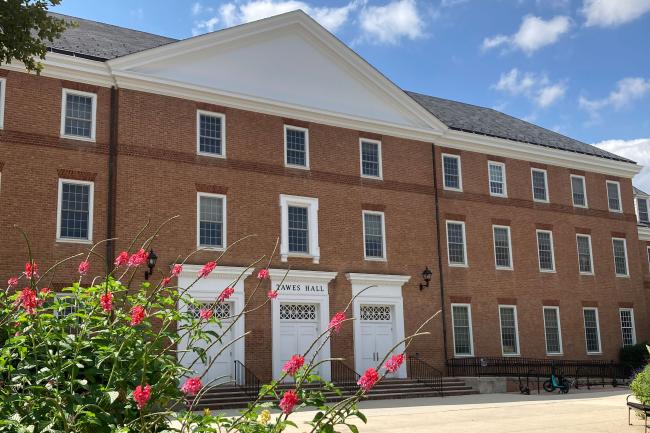 Plaza side of Tawes Hall, with red flowers in foreground